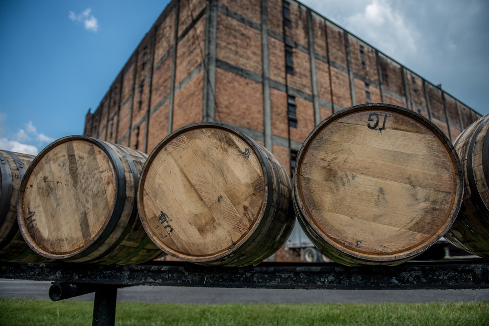 bourbon barrels in front of a rickhouse. Visiting Bourbon distilleries is one of the best things to do in Bardstown KY