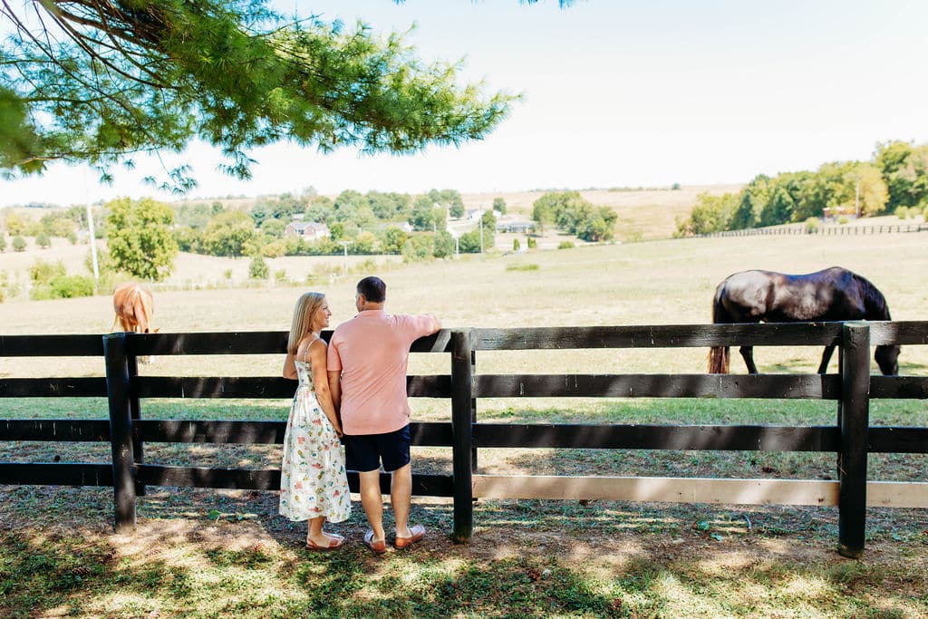 Couple standing at the fence at our Kentucky Horse Farm Bed and Breakfast, one of themost unique places to stay in Kentucky.
