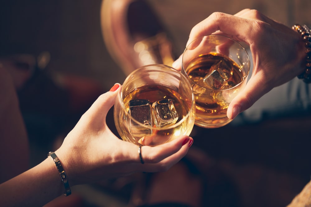 couple sharing a glass of bourbon at one of the best restaurants in Bardstown, KY