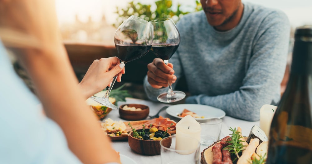 Couple sharing red wine and a delicious meal at the best restaurants in Bardstown, KY