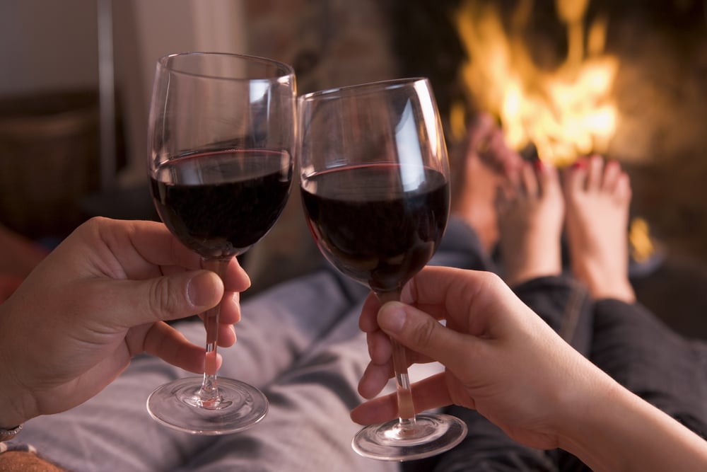 A couple drinking wine and enjoying their romantic getaways in kentucky by the fire