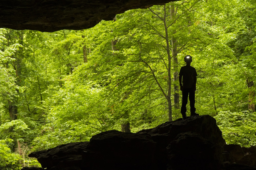 Silhouette of a figure heading underground to one of the best caves in Kentucky
