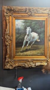 Antique Shopping find - picture of white horse painting framed in a large gold frame.