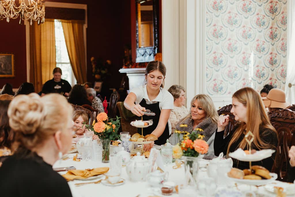 group pf ladies sitting at a dining table being served tea