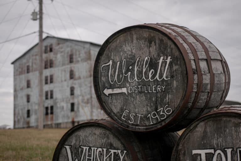 Tour Willett Distillery this winter. Willett Barrels with arrow in front of rickhouse.