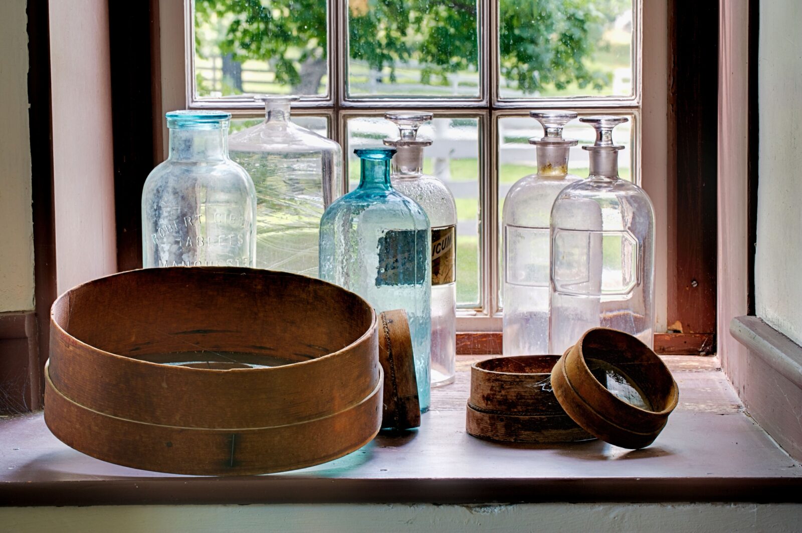 Antique bottles and shaker boxes on windowsill at Shaker Village Kentucky.